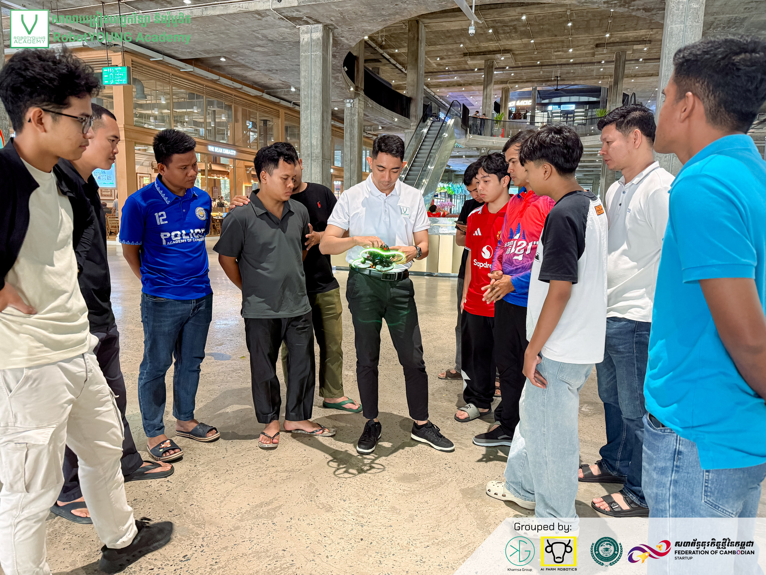 A group gathering around a small device during a workshop demonstration