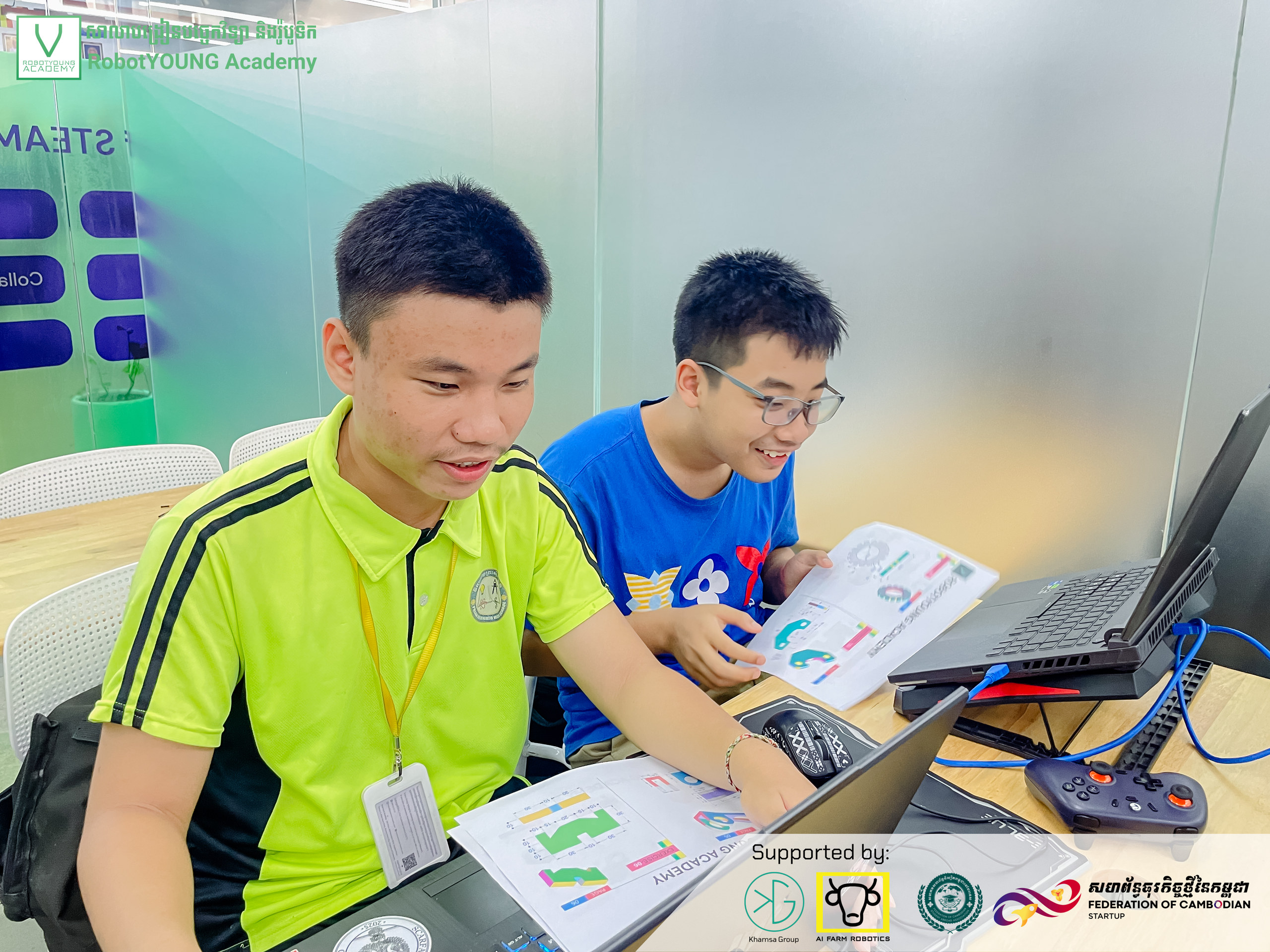 Two learners reviewing printed instructions together at a laptop